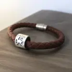 a brown leather bracelet with a silver bead